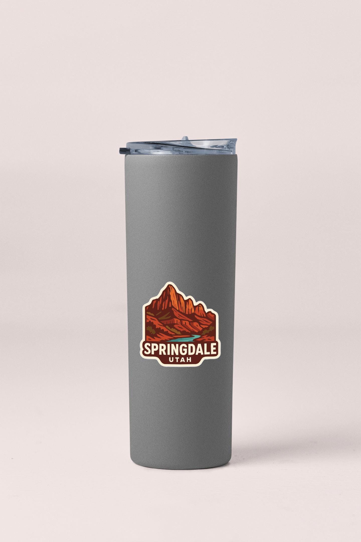 A gray insulated tumbler with a logo depicting a mountain range and the text "Springdale, Utah" printed on it.