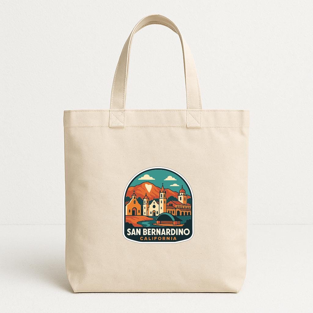 A beige tote bag with a printed design of a cityscape and the text "SAN BERNARDINO CALIFORNIA" printed on it.