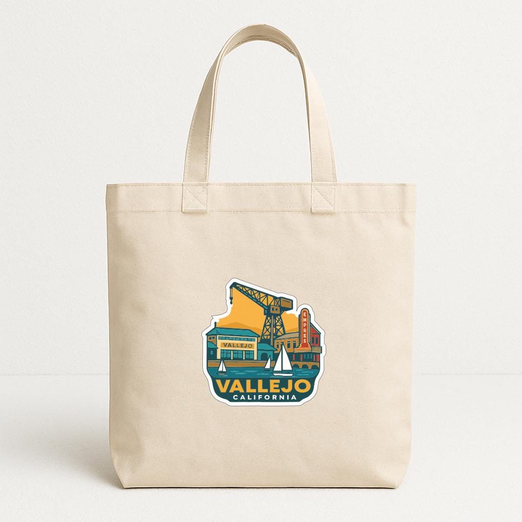 A beige tote bag with a printed design depicting a cityscape and the text "VALLEJO CALIFORNIA".