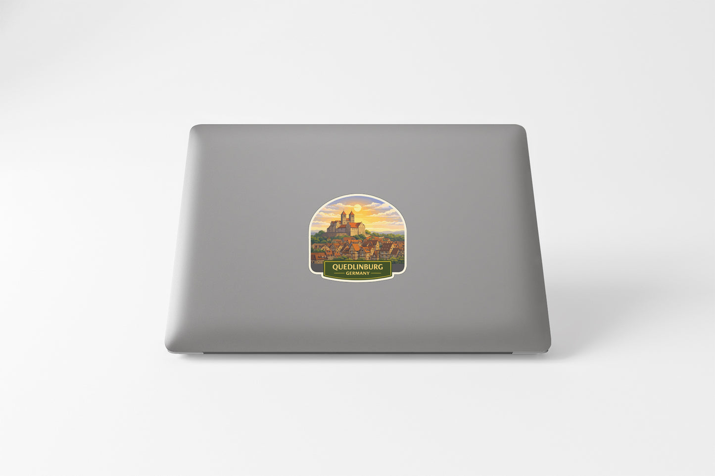a sticker with a castle on it, placed on the back of a laptop.