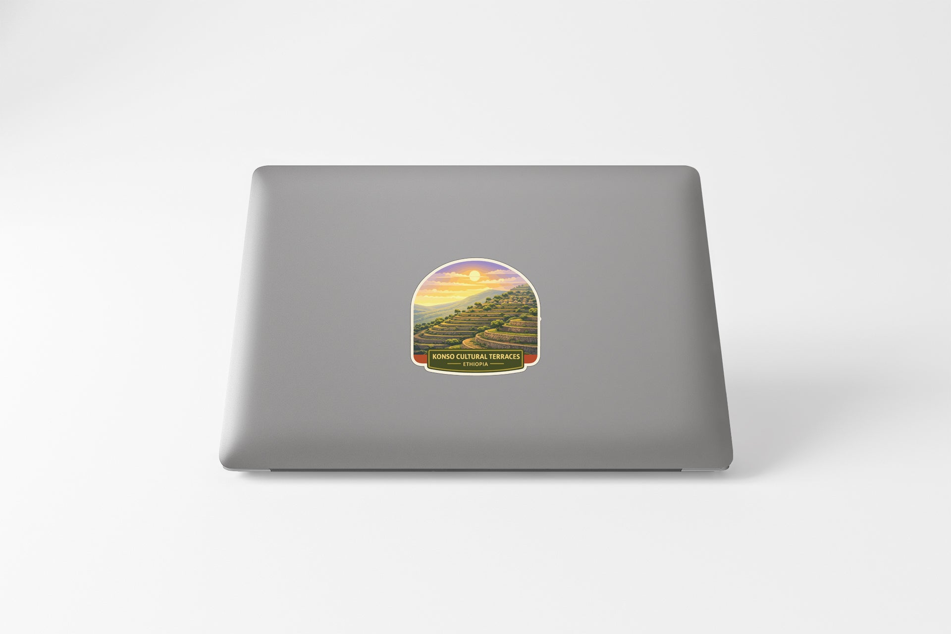 A sticker depicting a scenic landscape with a sunset over a mountain range.