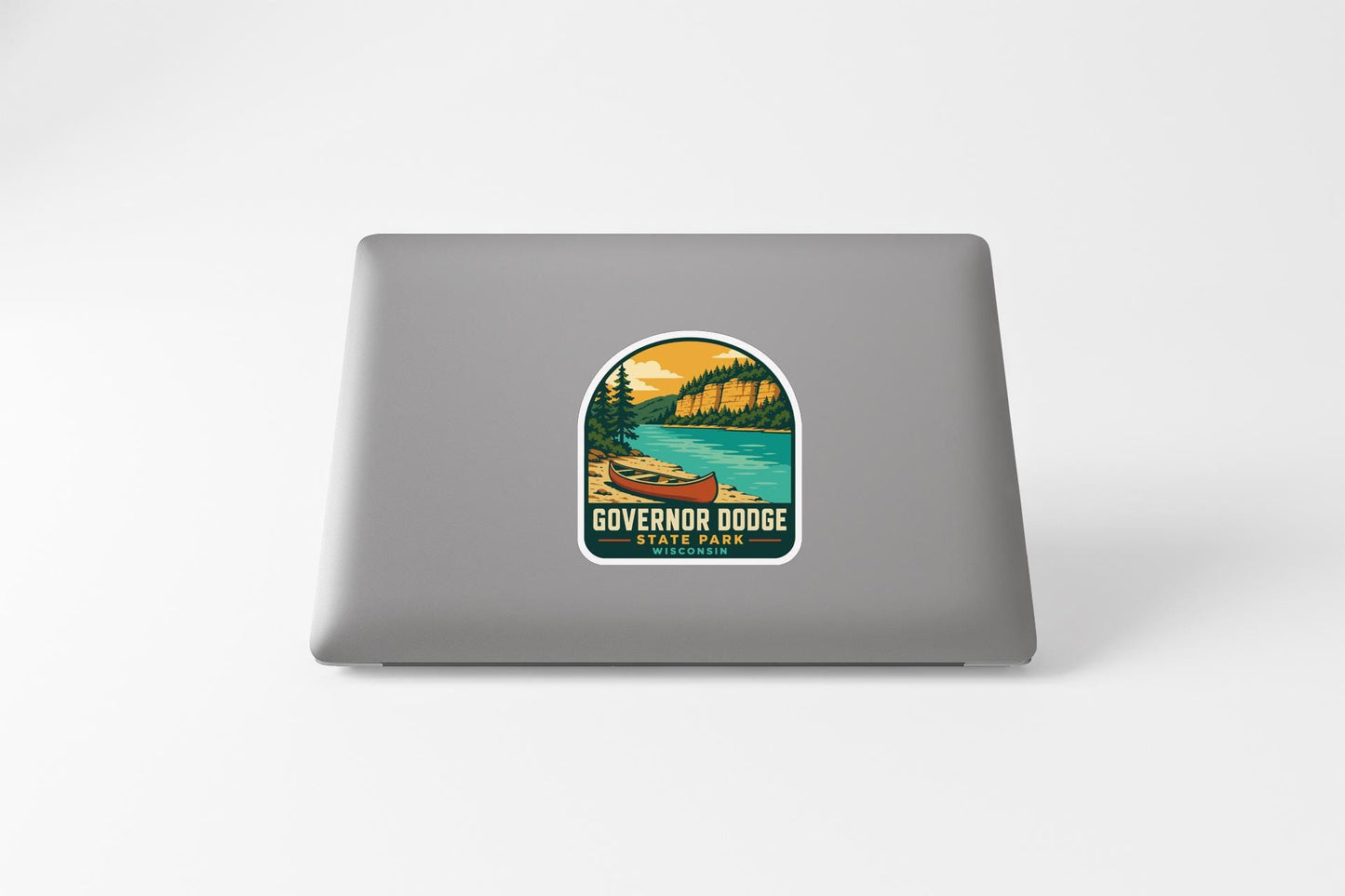 A sticker on the back of a laptop, depicting a scenic landscape with a lake, mountains, and a canoe.