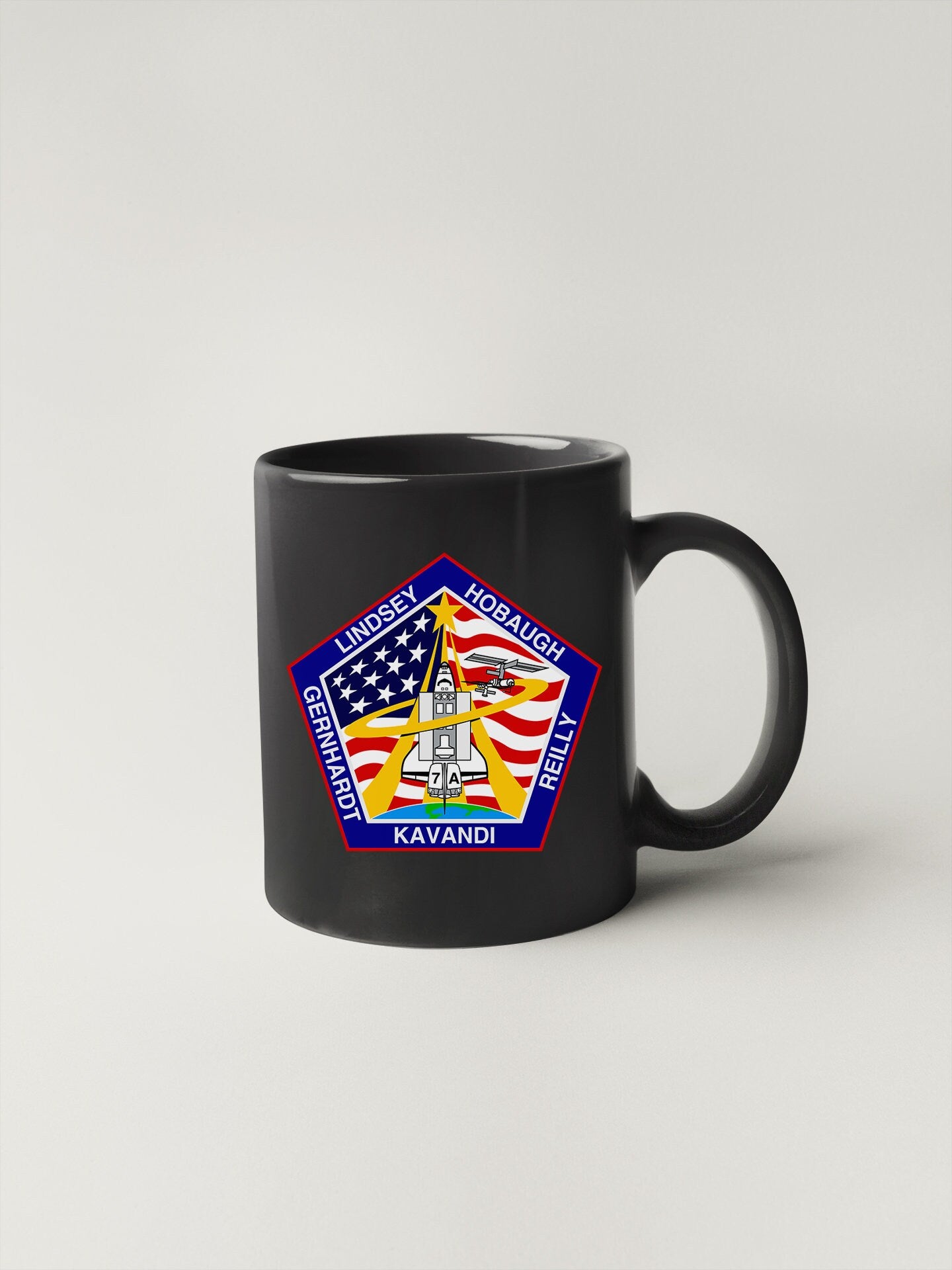 a black coffee mug with a nasa emblem on it
