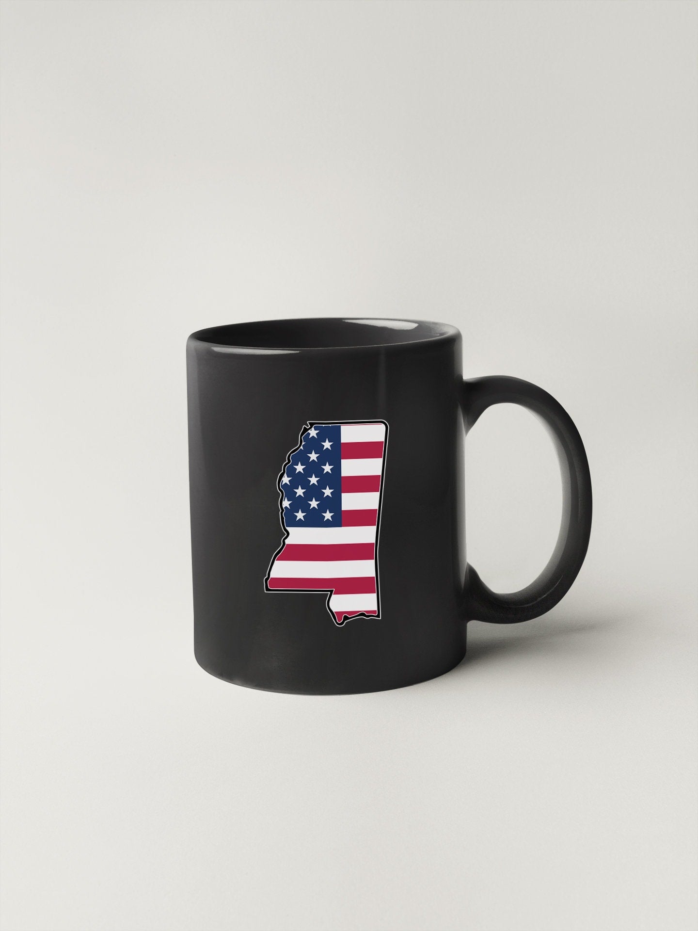 a black coffee mug with the shape of the united states of america painted on it