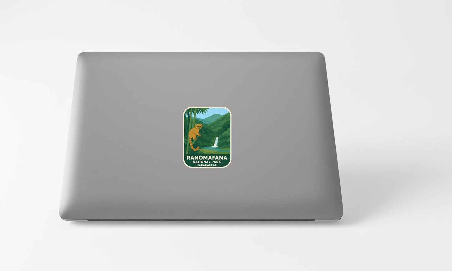 a sticker with a landscape and a yellow bird on a laptop.