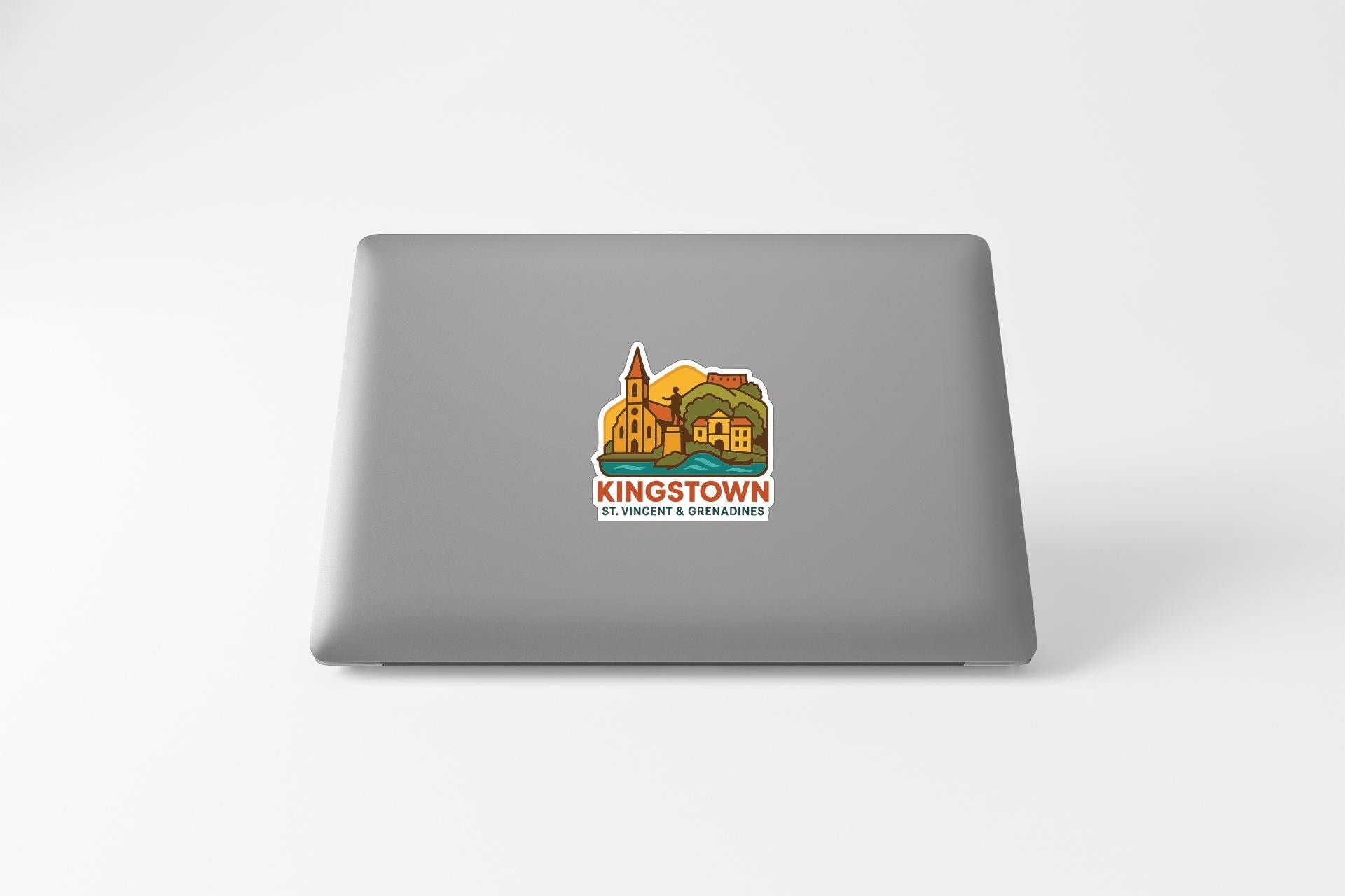 A sticker on the back of a laptop displaying an illustration of a town or village with a church and other buildings.