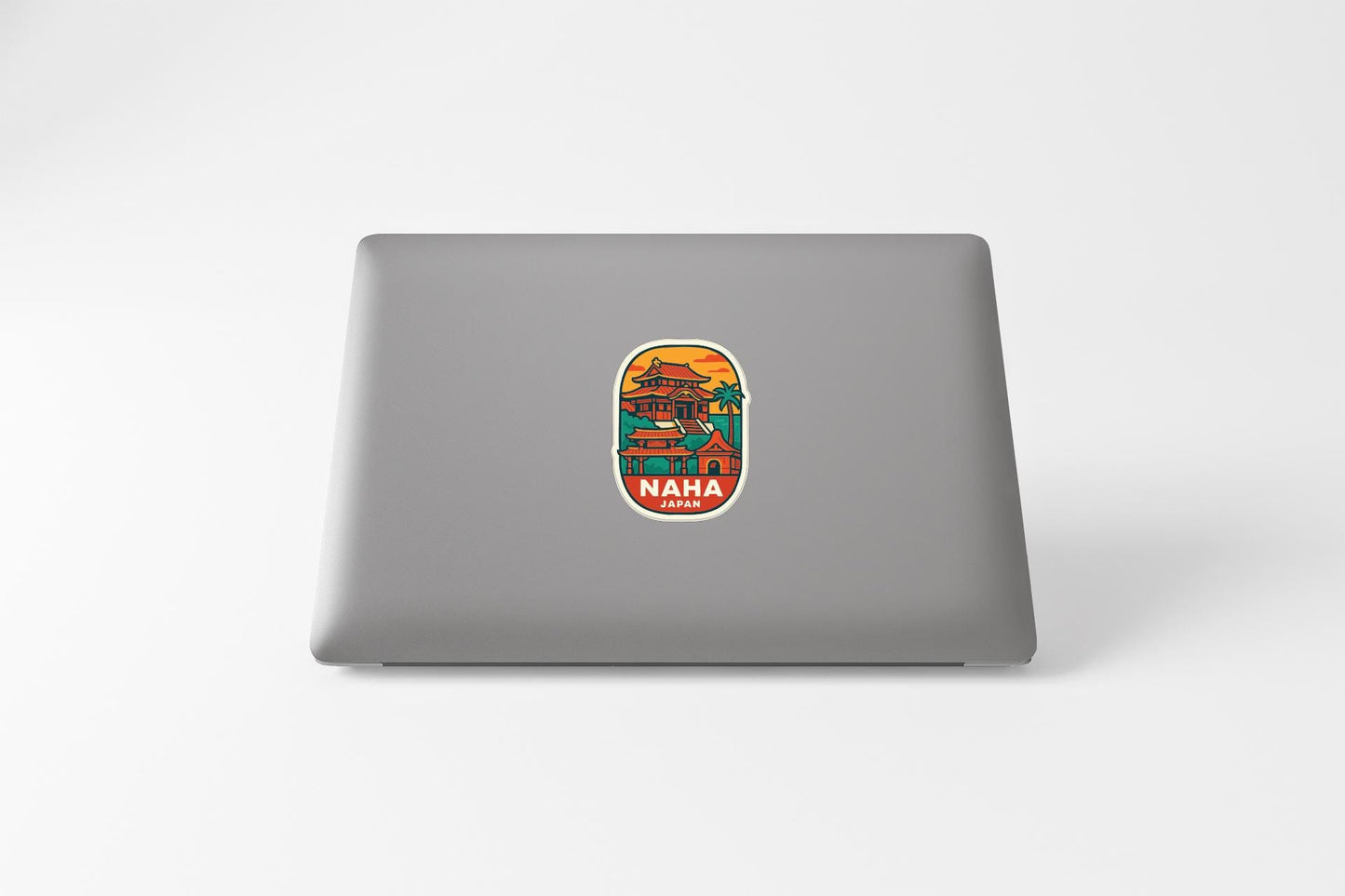 A sticker with a colorful illustration of a building and the word "NAPHAN" on a laptop.