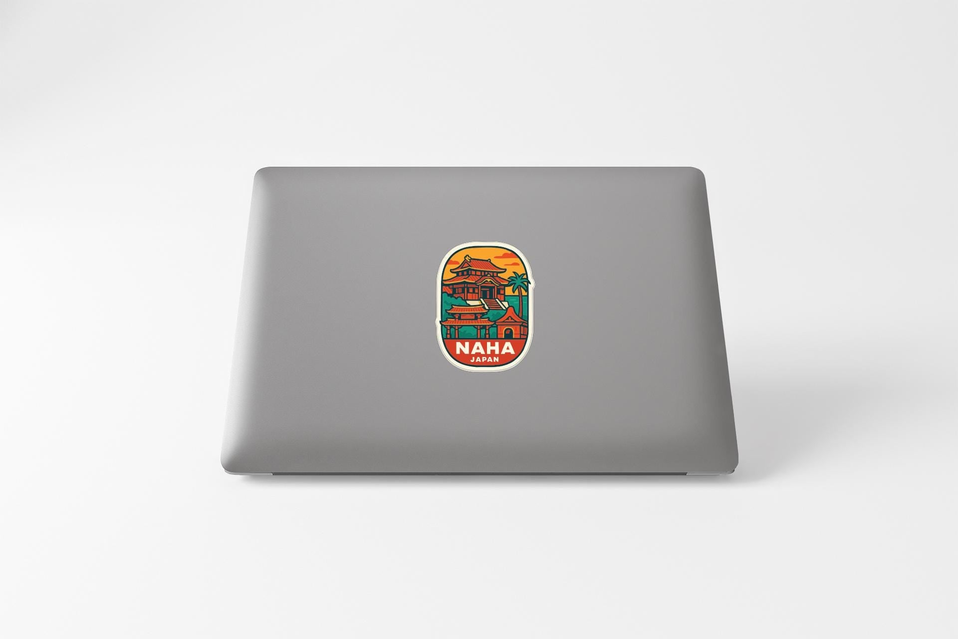 A sticker with a colorful illustration of a building and the word "NAPHAN" on a laptop.