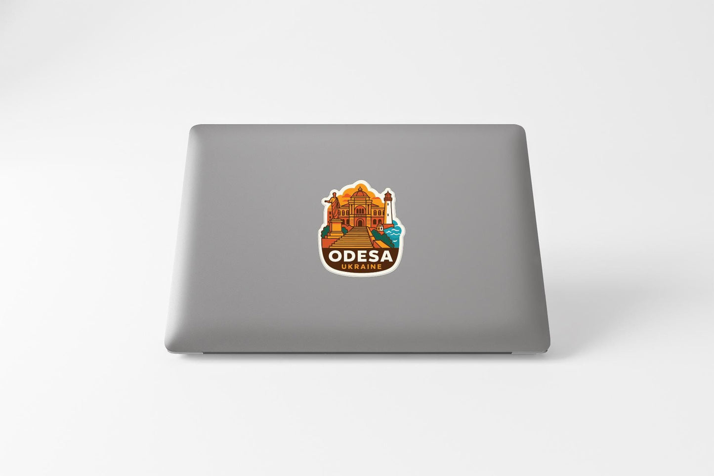 a sticker with an illustration of a building and the text "ODEESA" on the back of a laptop.