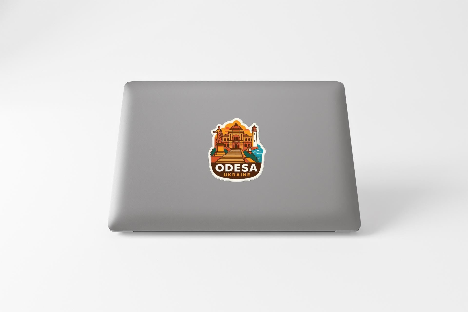 a sticker with an illustration of a building and the text "ODEESA" on the back of a laptop.