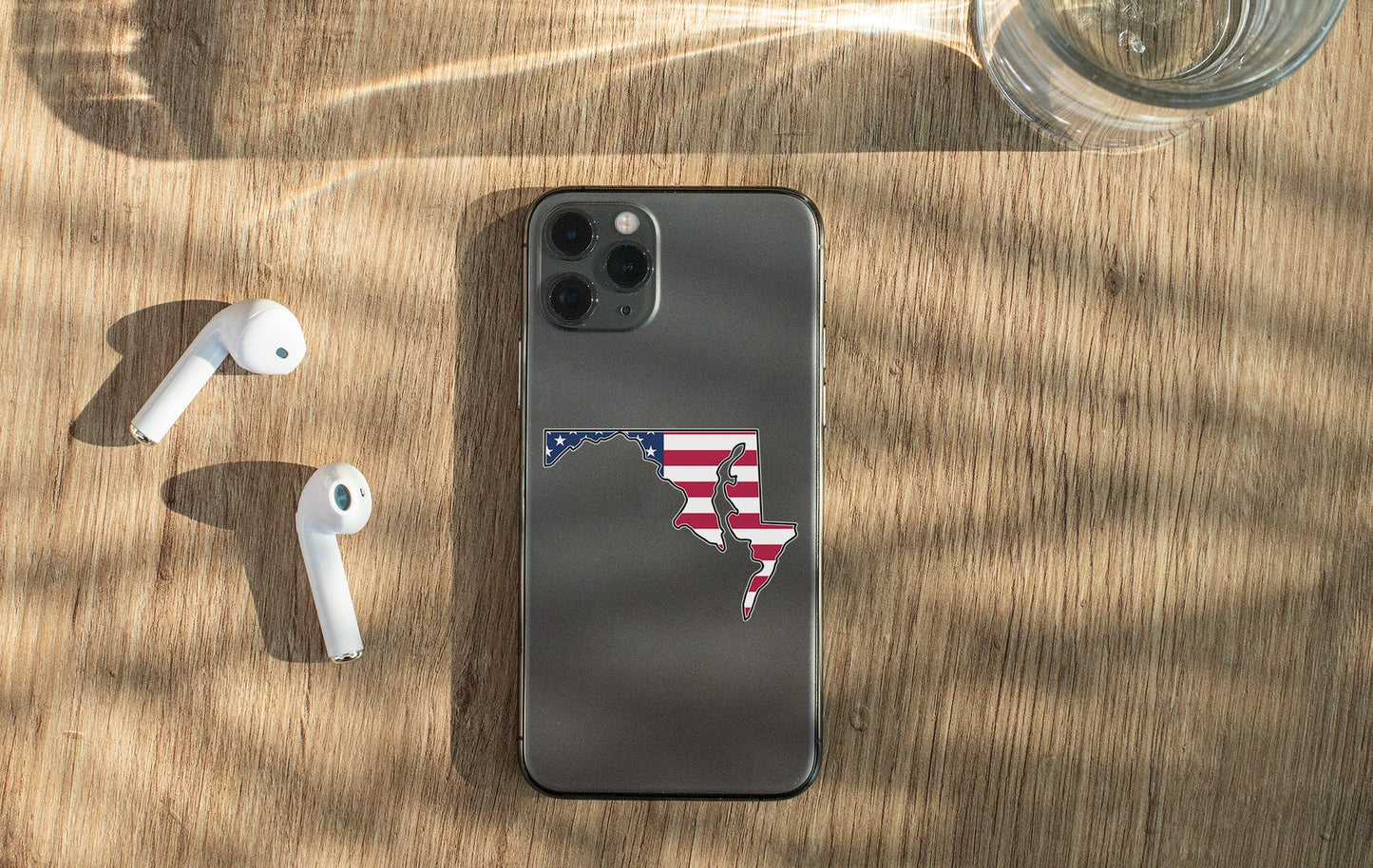 a phone with a sticker on it next to ear buds