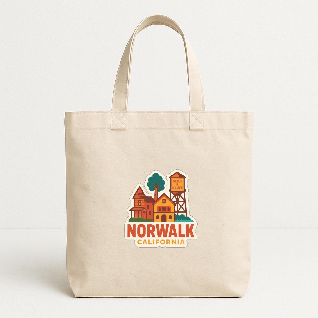 A beige tote bag with a printed design of a town and a water tower, along with the text "NORWALK CALIFORNIA".