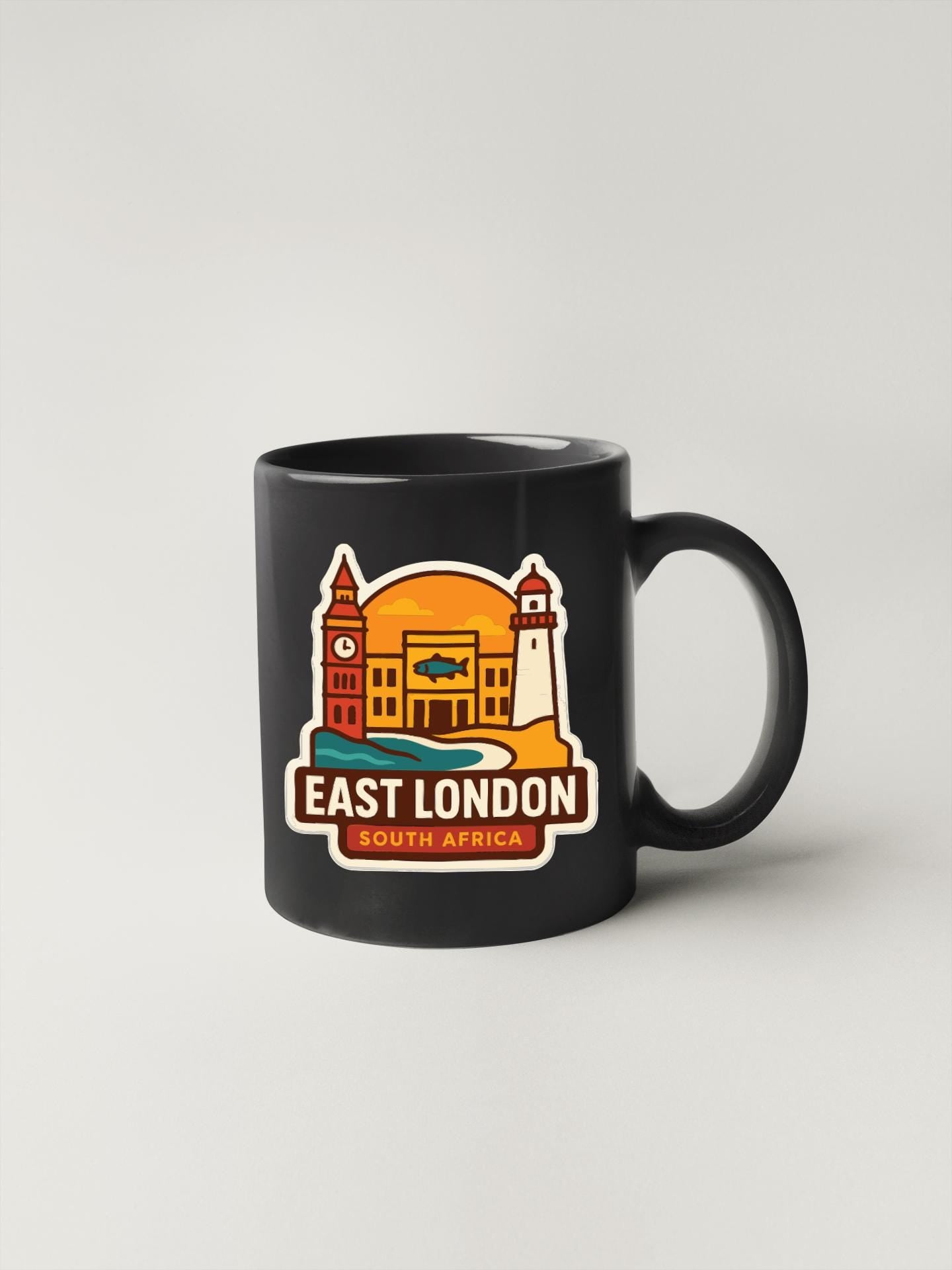 A black coffee mug with a colorful illustration of landmarks and text that says "EAST LONDON SOUTH AFRICA".