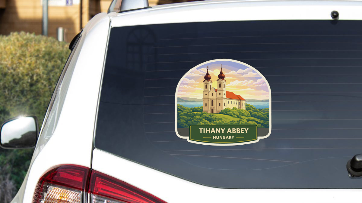 A sticker on the rear window of a car depicting the Tihany Abbey, a historic landmark in Hungary.