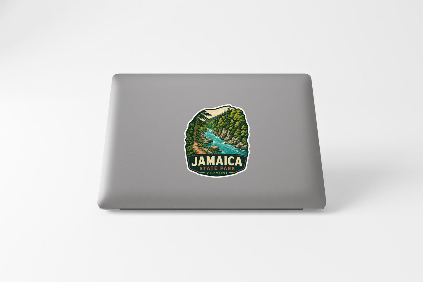 A sticker on the back of a laptop, depicting a scenic landscape with a river and mountains.