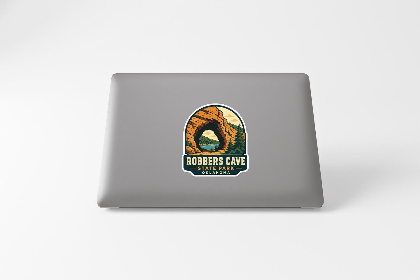 a sticker or decal on the back of a laptop, depicting a scenic landscape with a cave or tunnel.