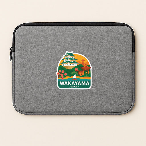A gray laptop sleeve with a sticker depicting a scenic view of Wakayama, Japan.