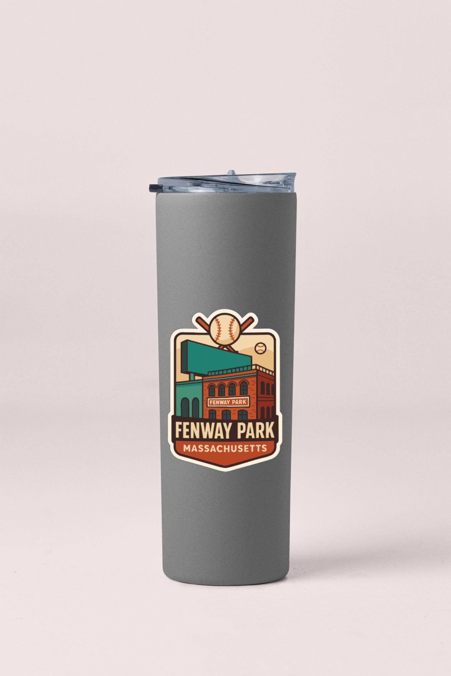 A gray insulated tumbler with a sticker depicting Fenway Park, a baseball stadium in Boston, Massachusetts.