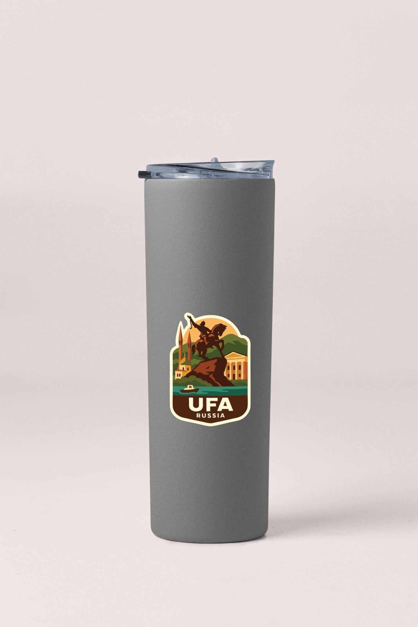 A gray insulated tumbler with a sticker featuring a graphic of a person and the text "UFA RUSSIA" printed on it.