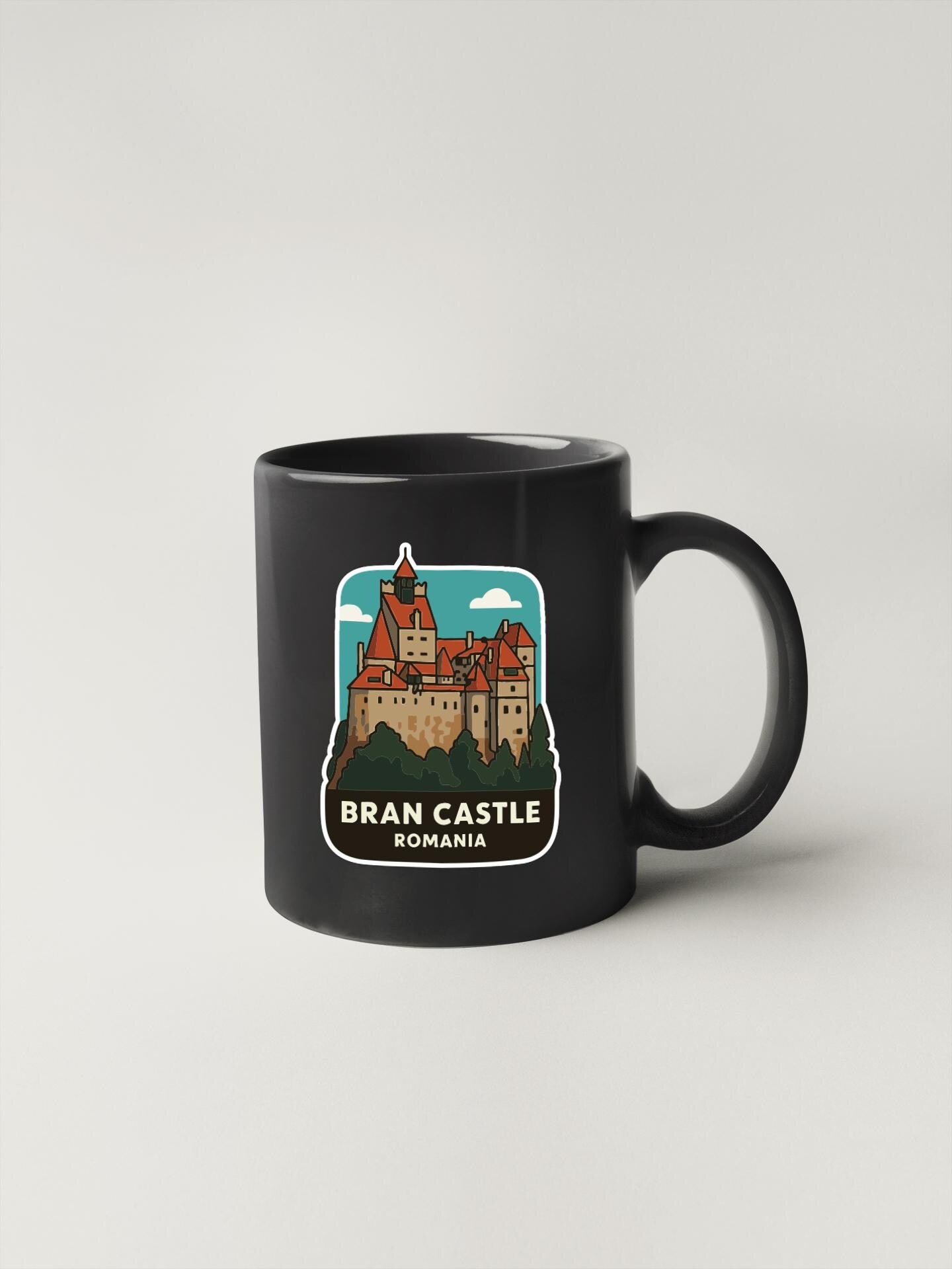 A black coffee mug with a graphic of Bran Castle, a historic castle located in Romania.