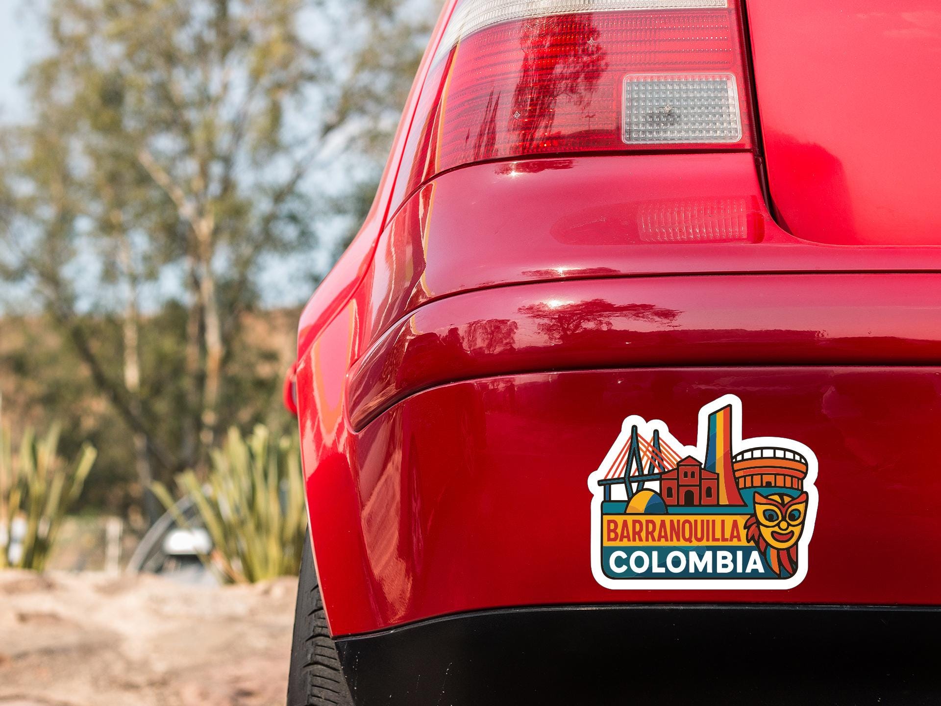 the rear end of a red car with a sticker on the trunk that says "BARRANQUILLA COLOMBIA".