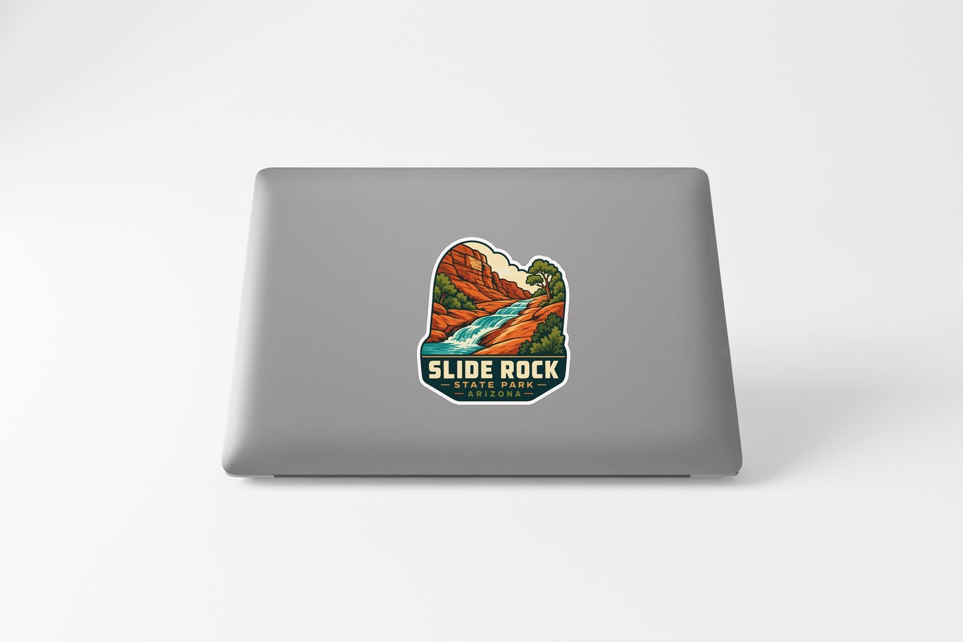 A sticker featuring a scenic landscape with a river and mountains, along with the text "SLIDE ROCK STATE PARK".