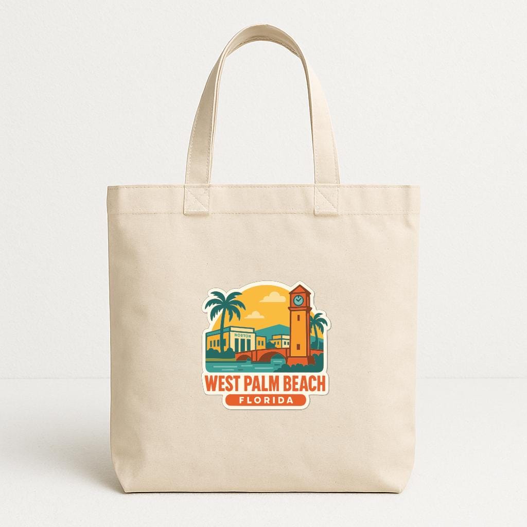 A beige tote bag with a printed design depicting a tropical beach scene, including palm trees, a clock tower, and a sunset.