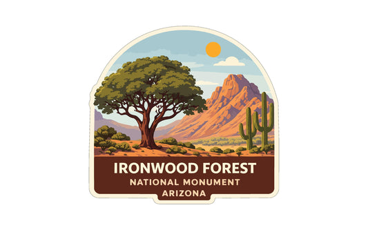 a label or emblem for the Ironwood Forest National Monument in Arizona. It depicts a desert landscape with a large tree, cacti, and mountains in the background.