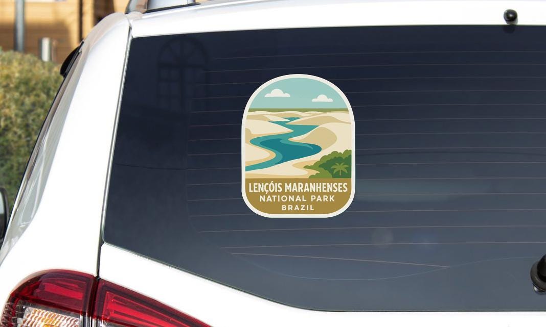 a sticker on the rear window of a car, depicting a scenic landscape with a river and mountains.