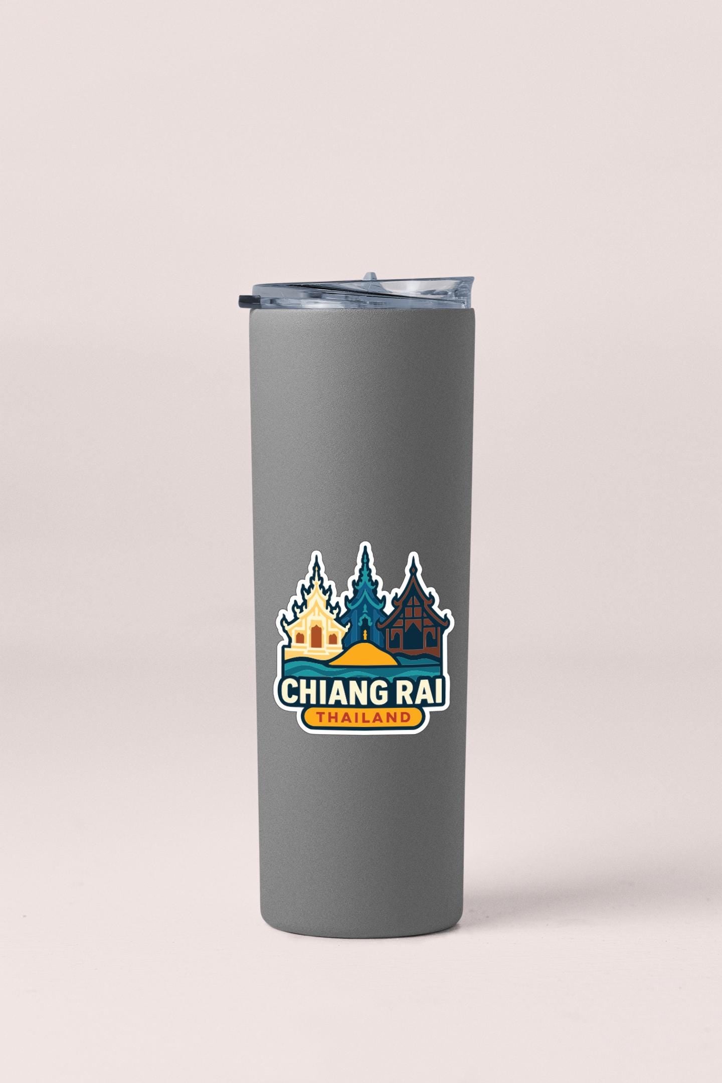 A gray insulated tumbler with a sticker featuring a colorful illustration of buildings and trees, along with the text "CHIANG RAI THAILAND".