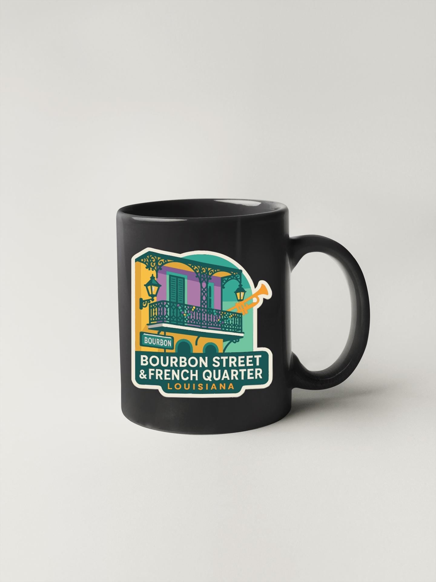 A black coffee mug with a colorful illustration of a building and text that says "BOURBON STREET & FRENCH QUARTER LOUISIANA".