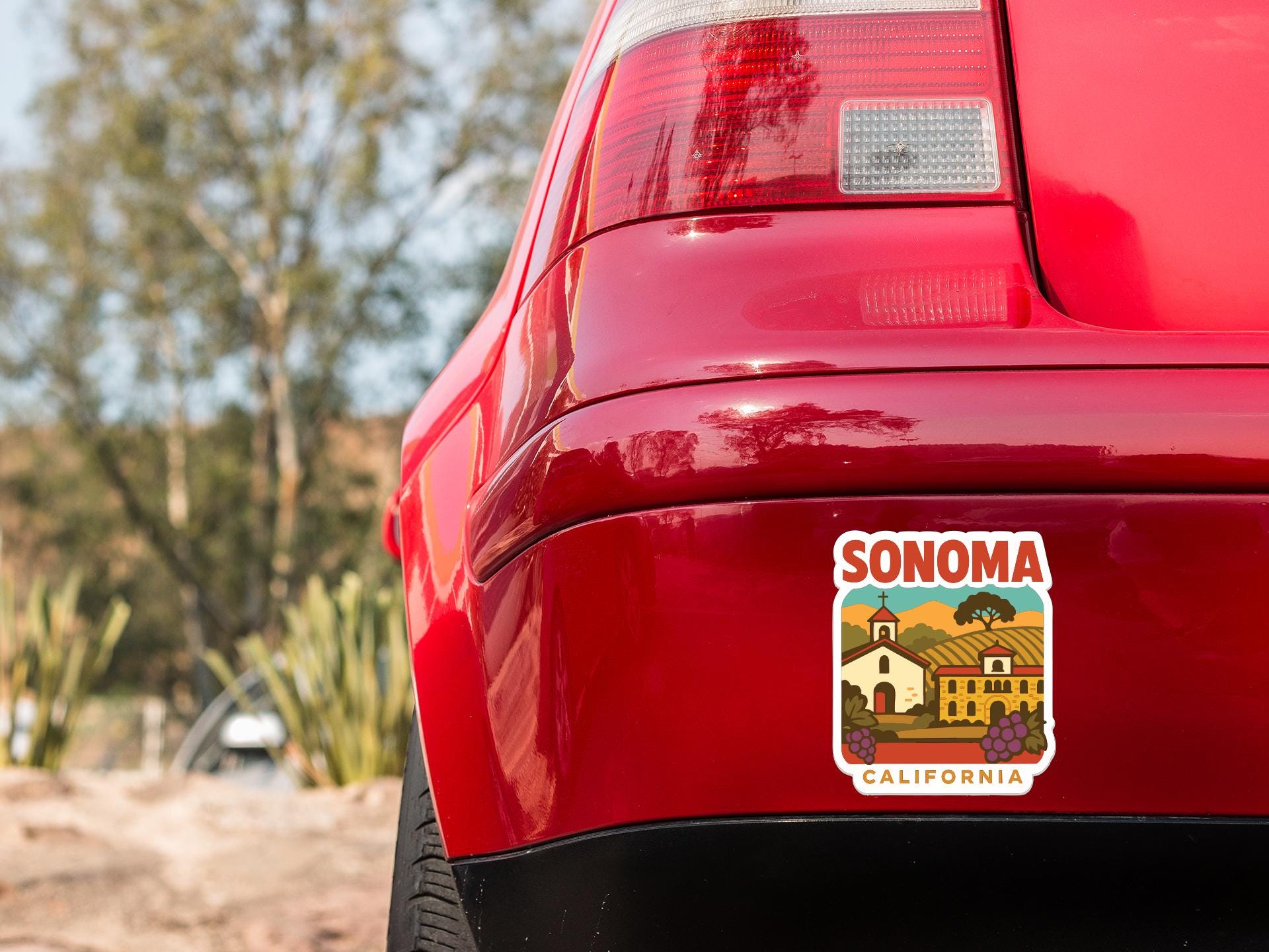 the rear end of a red car with a sticker on the back window that says "SONOMA, CALIFORNIA".