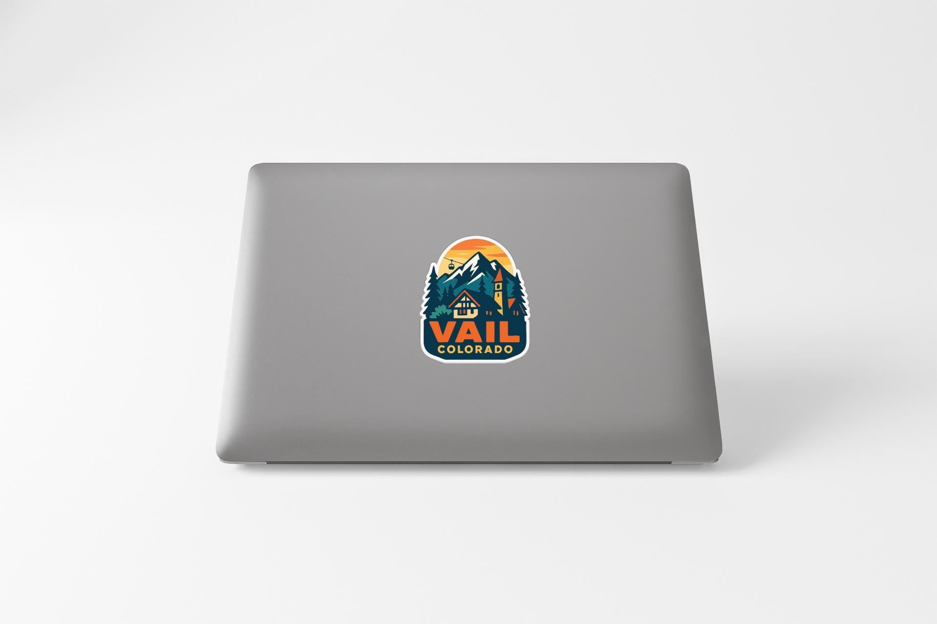 A sticker on the back of a laptop that says "Vail Colorado".