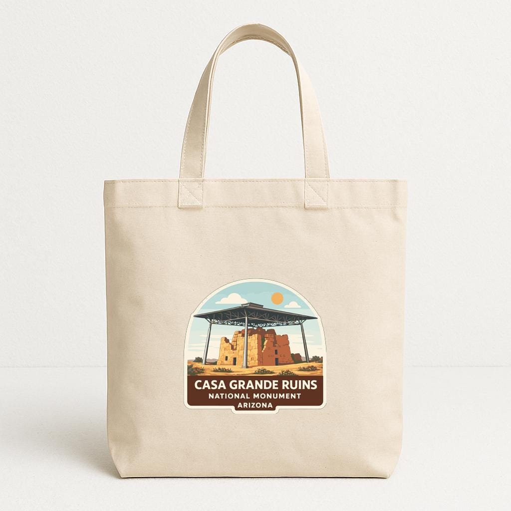 A beige tote bag with a label that says "CASA GRANDE RUINS NATIONAL MONUMENT ARIZONA" printed on it.