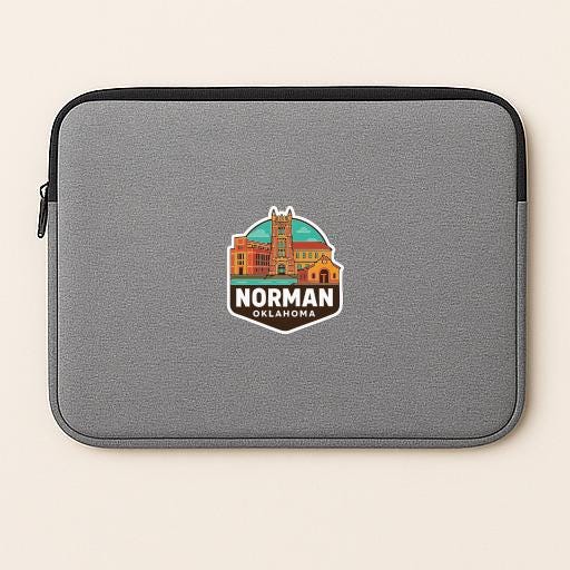 A gray laptop sleeve with a sticker of Norman, Oklahoma on it.