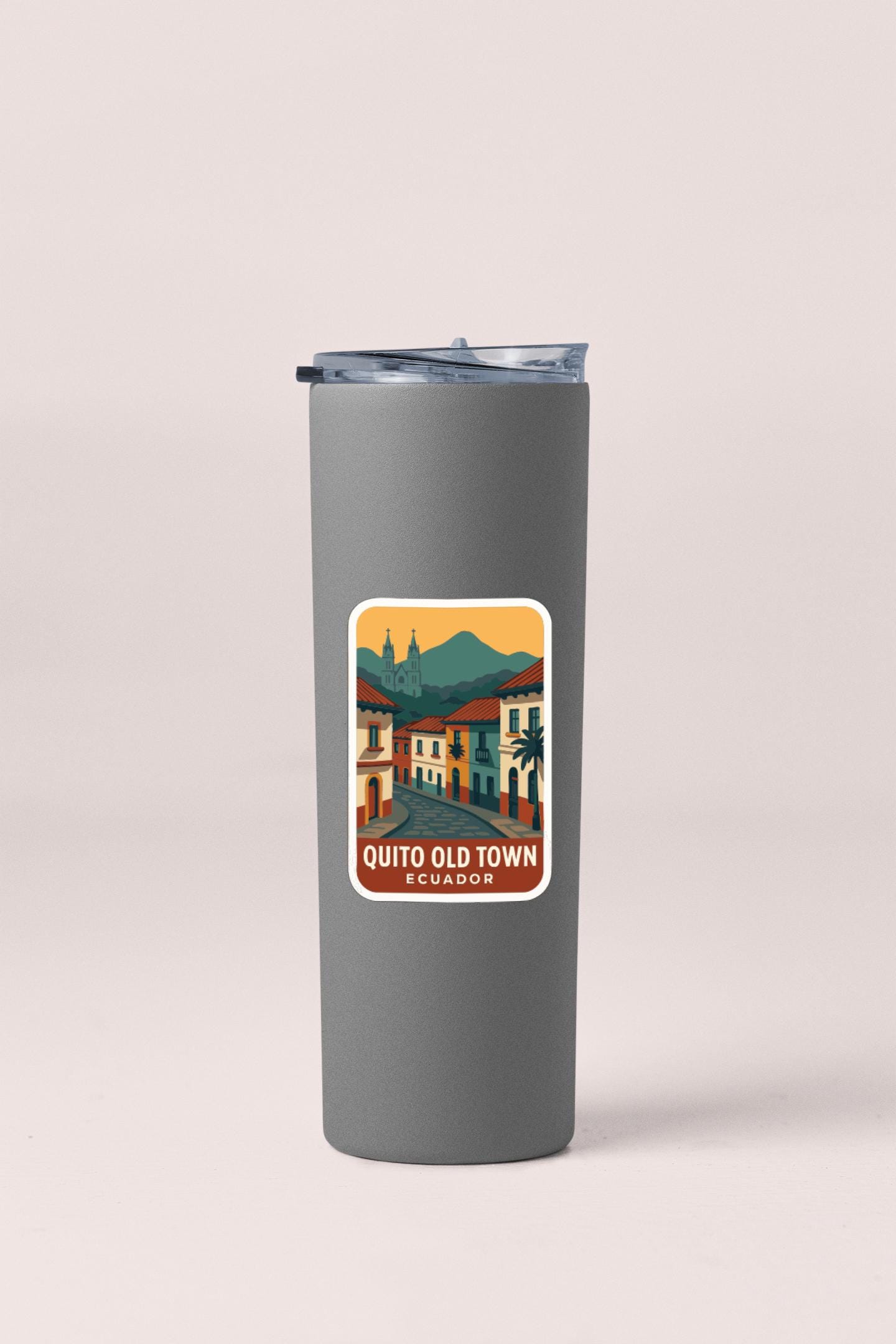 A gray insulated tumbler with a sticker depicting a colorful illustration of Quito Old Town in Ecuador.