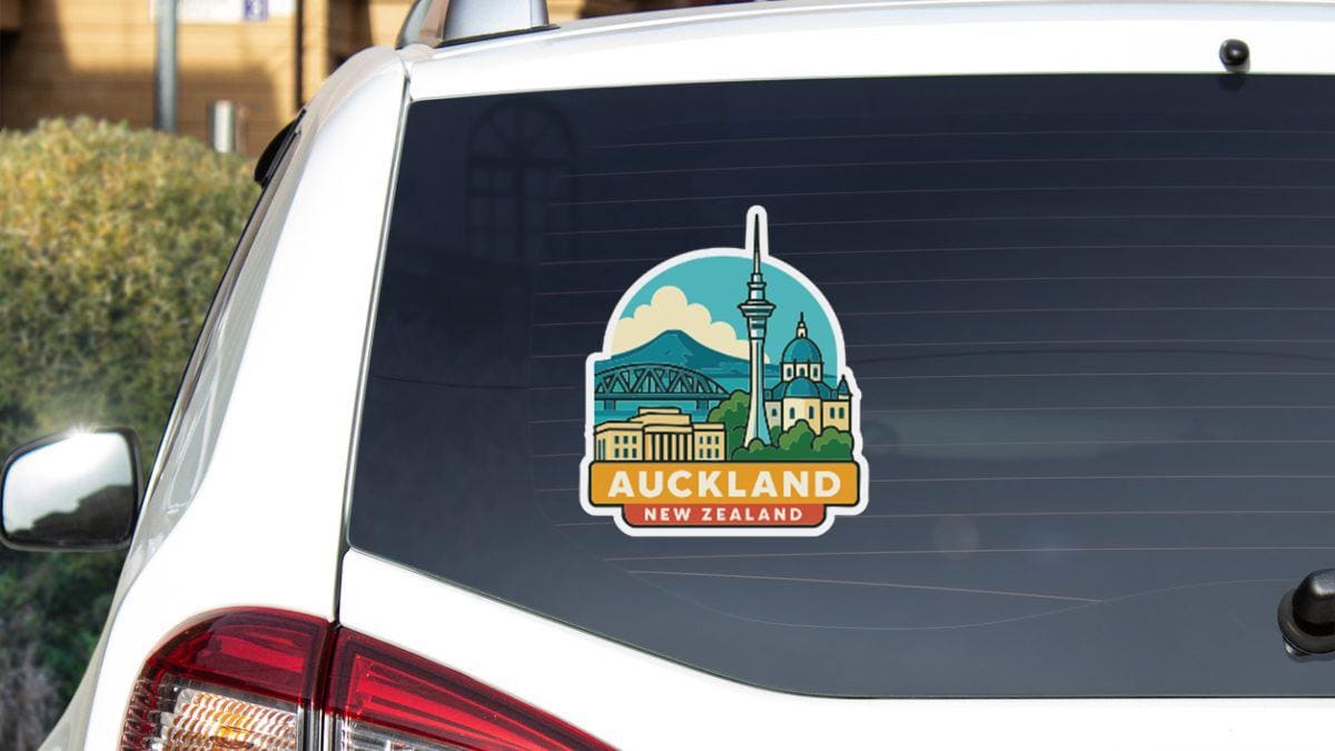A sticker on the rear window of a car, depicting the iconic skyline of Auckland, New Zealand.