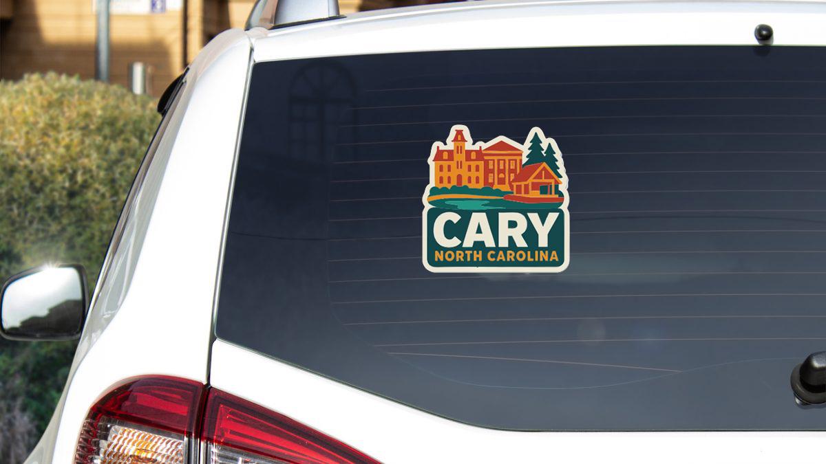 A sticker on the rear window of a white car, displaying the text "CARY NORTH CAROLINA".