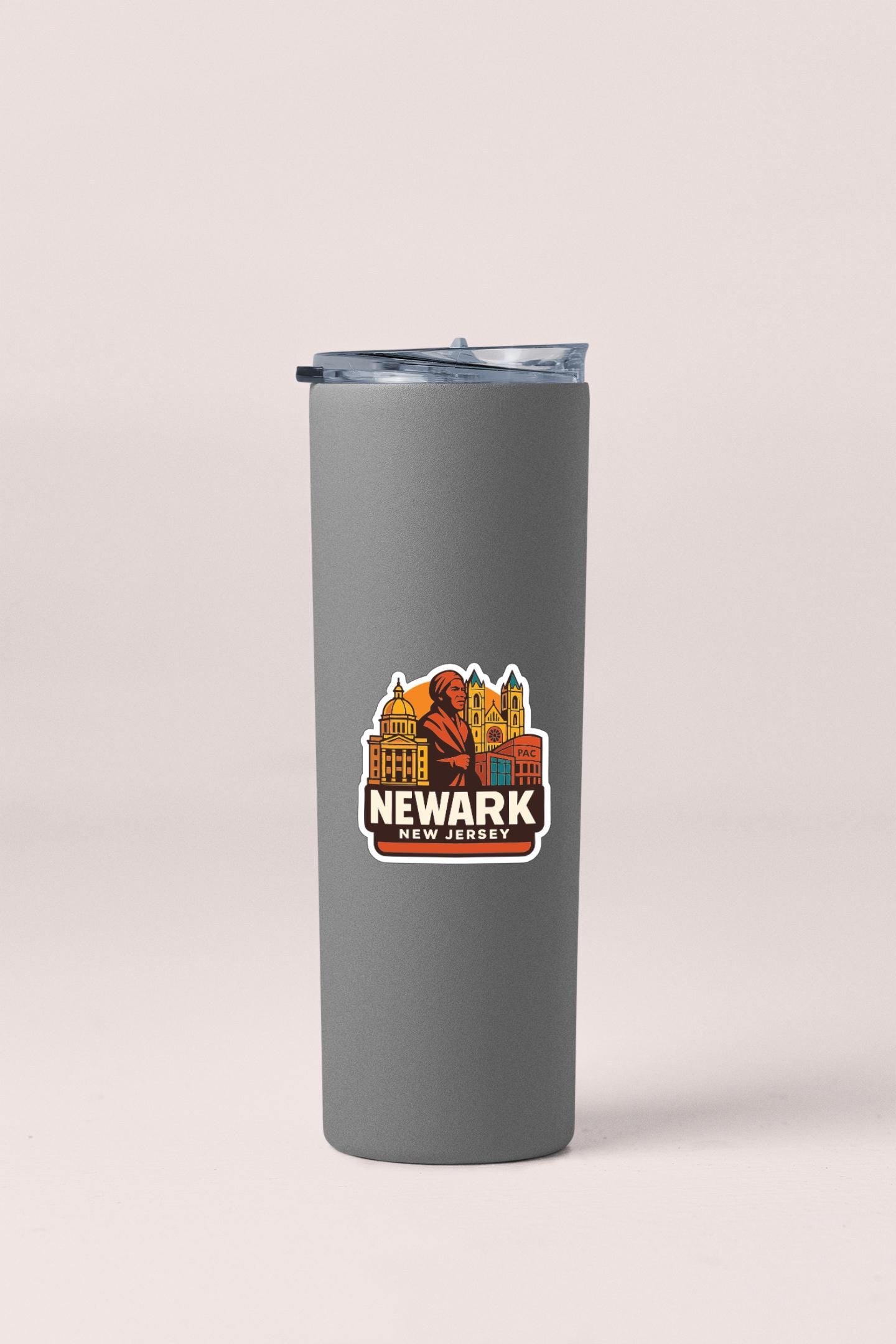 A gray insulated tumbler with a Newark, New Jersey cityscape sticker on it.