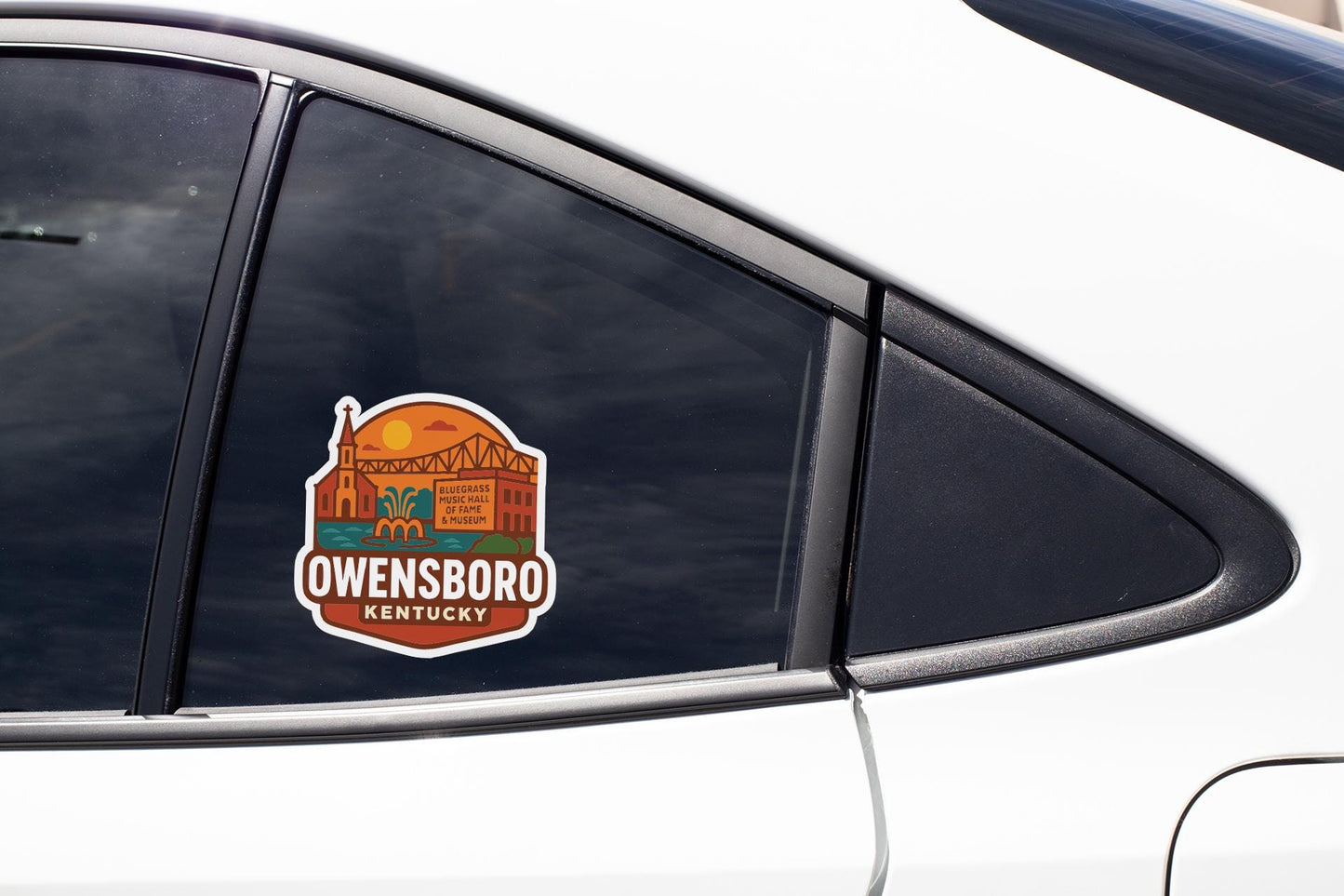 A sticker on the side of a car window, featuring an illustration of a bridge and the text "Owensboro, Kentucky".