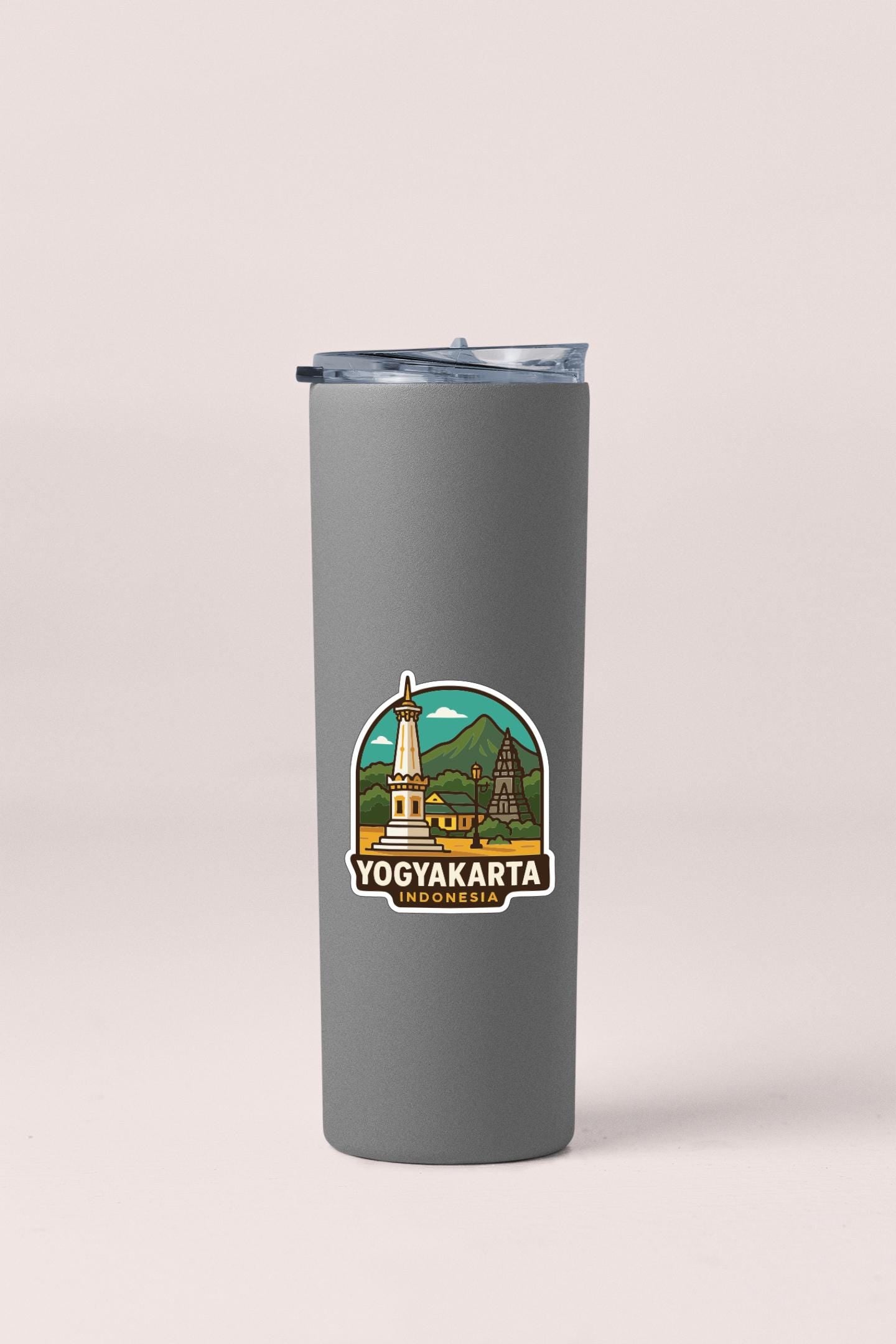 A gray insulated tumbler with a sticker depicting the Yogyakarta, Indonesia landmark.