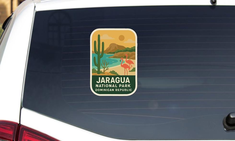 A sticker on the rear window of a car, depicting a scenic landscape with a desert, a cactus, and a flamingo.