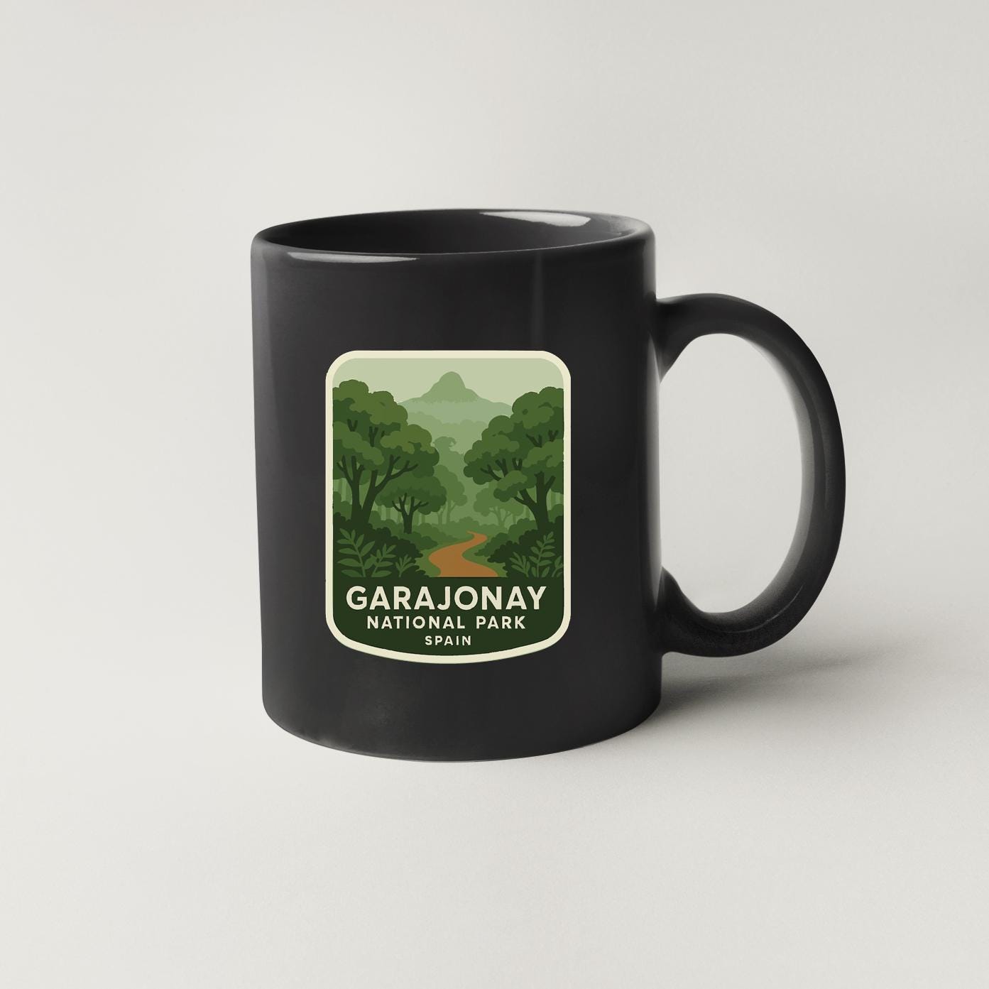 A black coffee mug with a label that says "GARAJONAY NATIONAL PARK SPAIN".