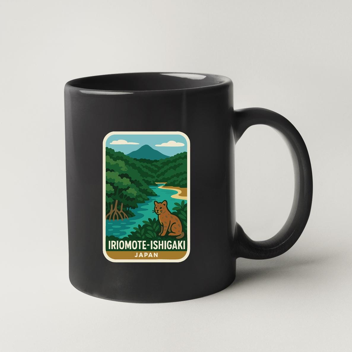 A black coffee mug with a sticker depicting a scenic landscape of a river, mountains, and a cat.