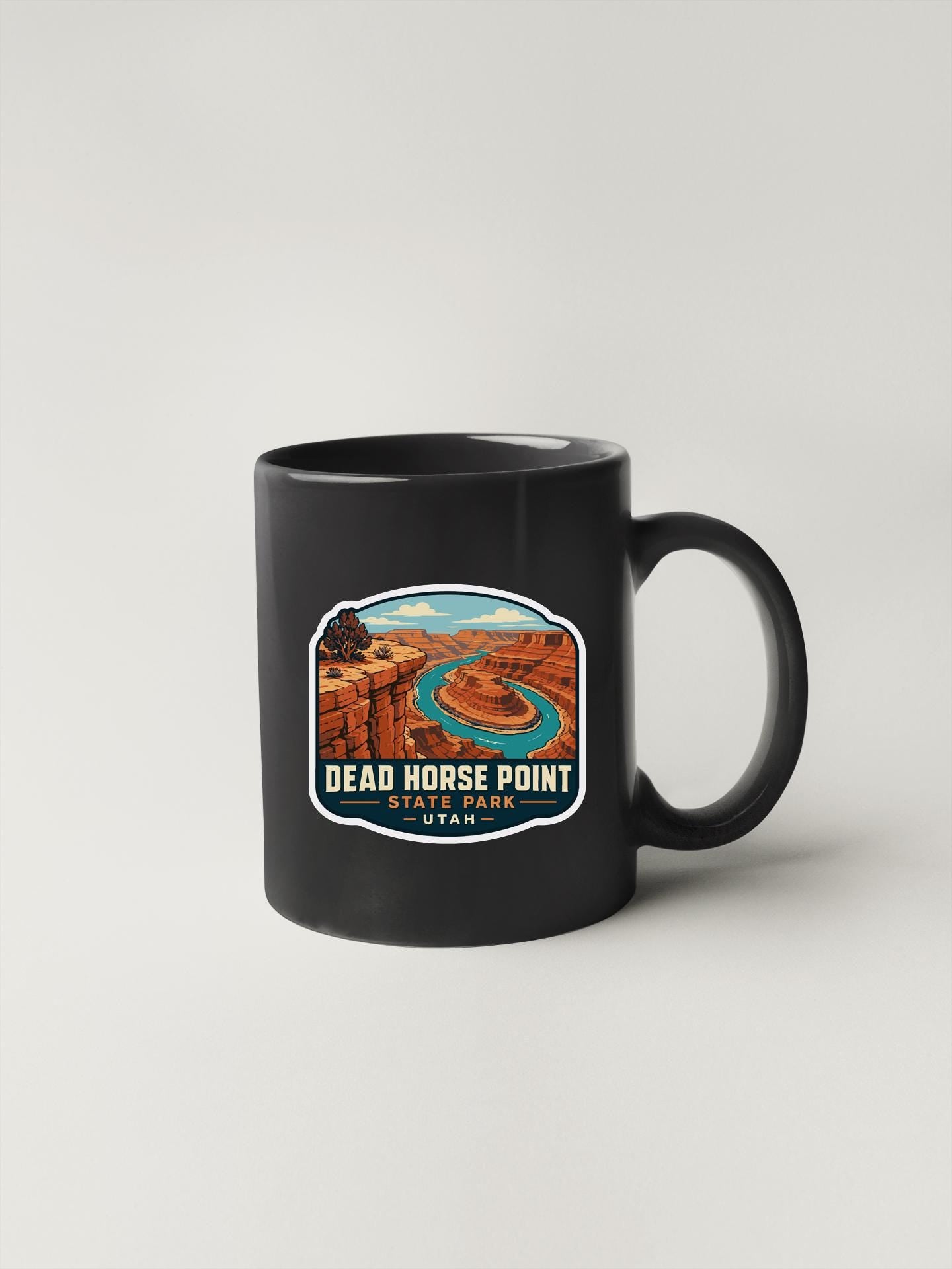 A black coffee mug with a graphic design depicting the Dead Horse Point in Utah.