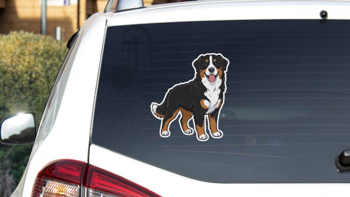 a sticker of a dog on the rear window of a car.