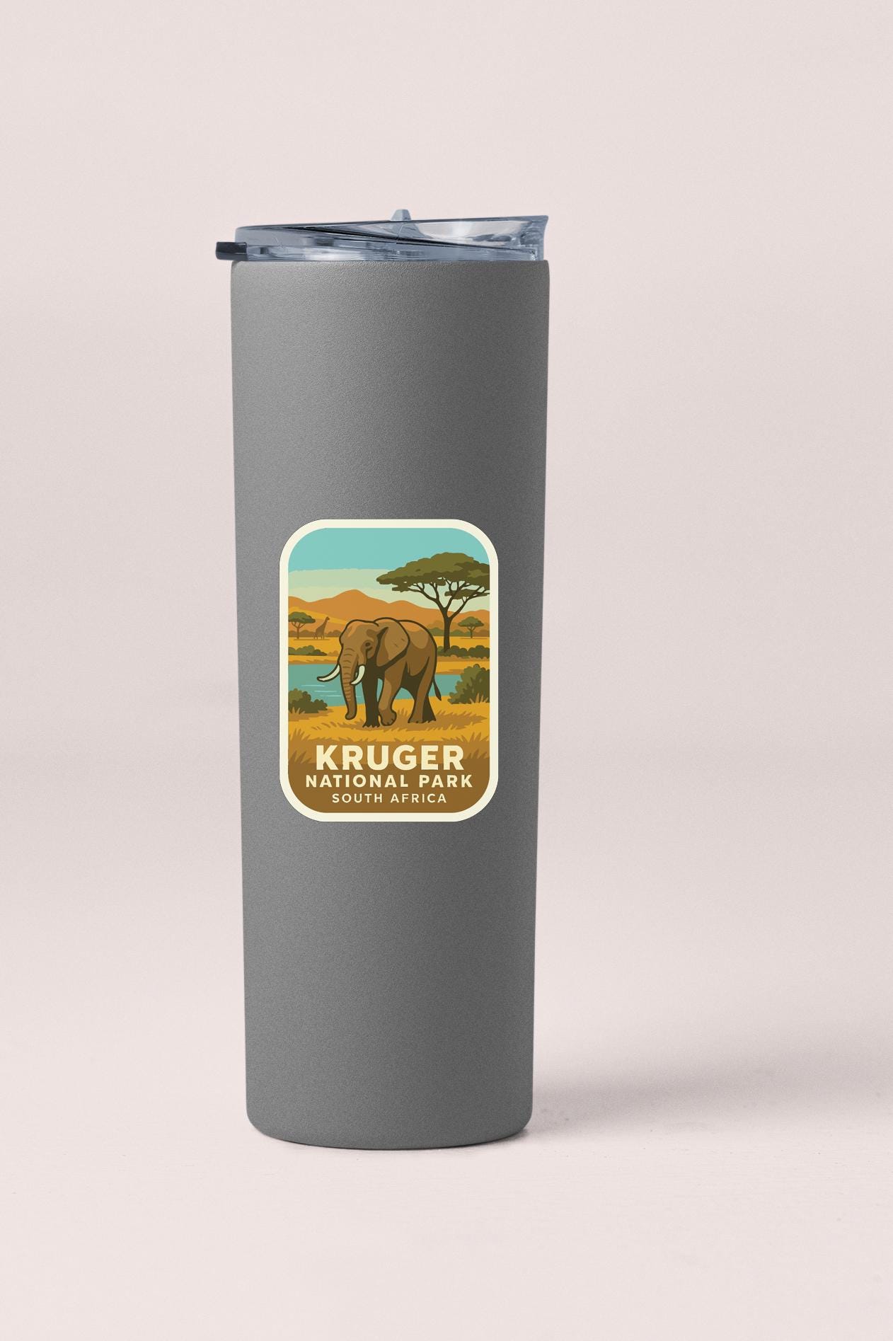 A gray tumbler with a label that features an illustration of an elephant in a savanna landscape, along with the text "Kruger National Park South Africa".