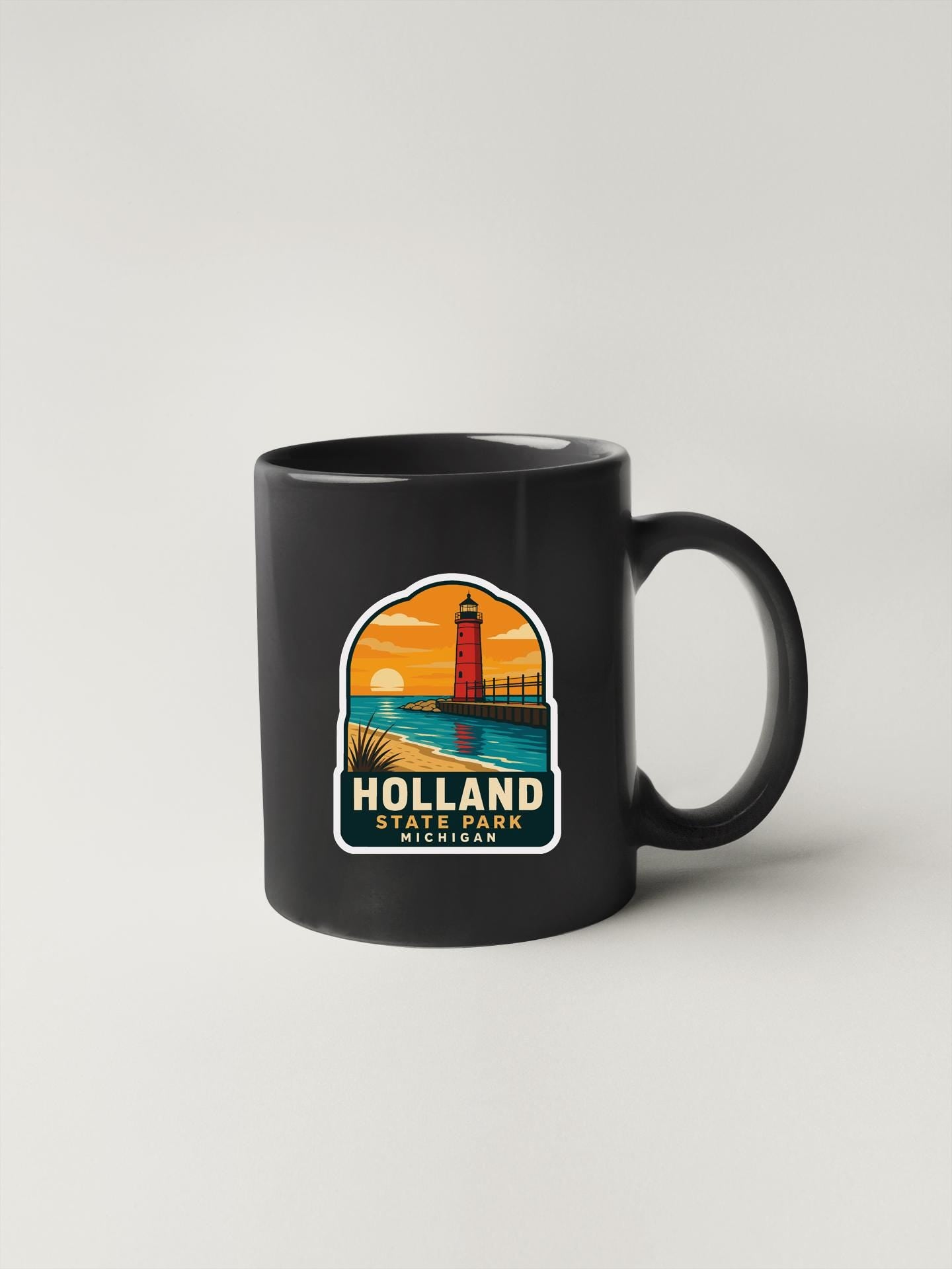 A black coffee mug with a graphic design depicting a lighthouse and a sunset over a body of water, representing Holland State Park in Michigan.