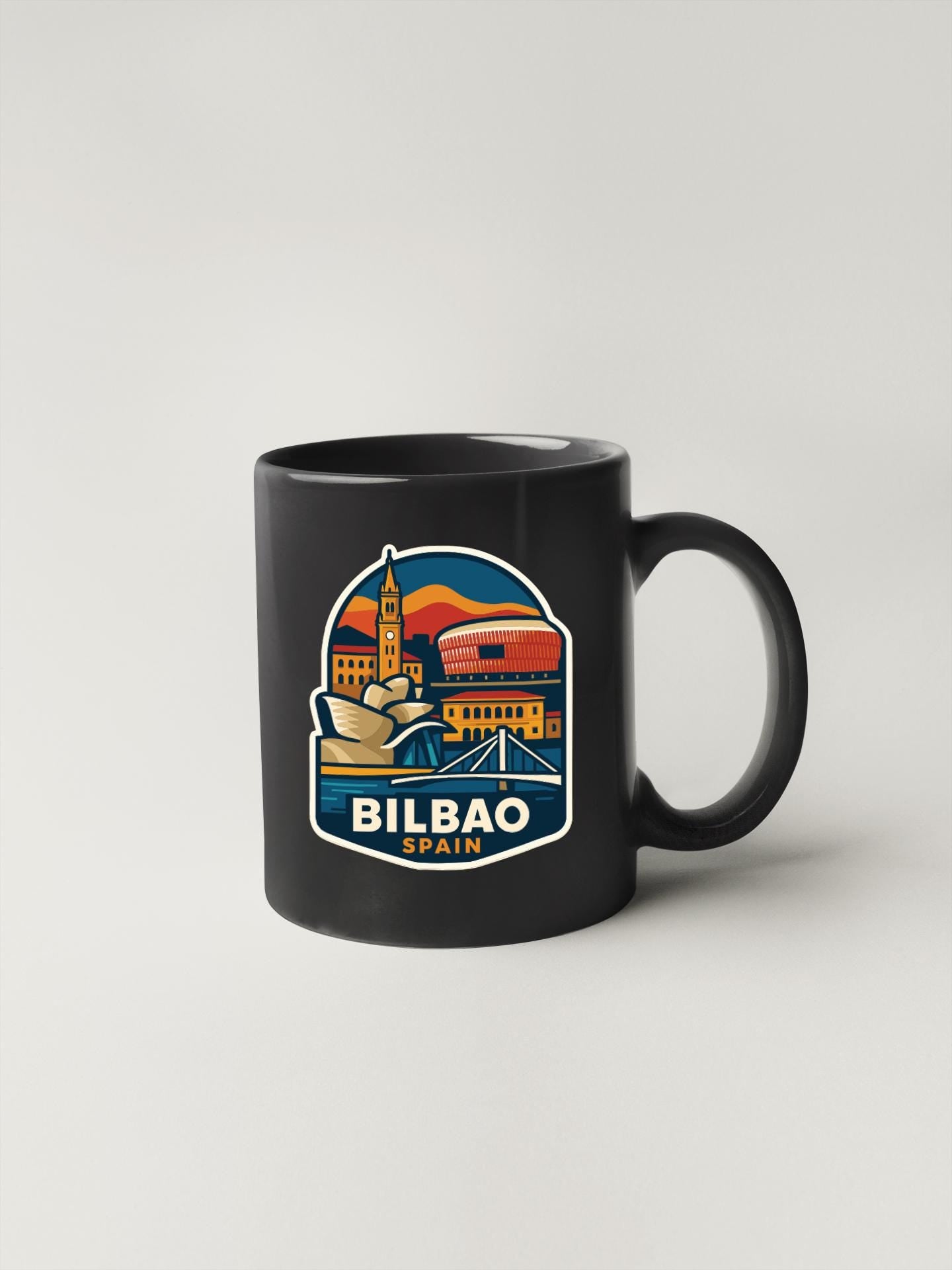 A black coffee mug with a colorful illustration of the city of Bilbao, Spain, featuring landmarks and buildings.