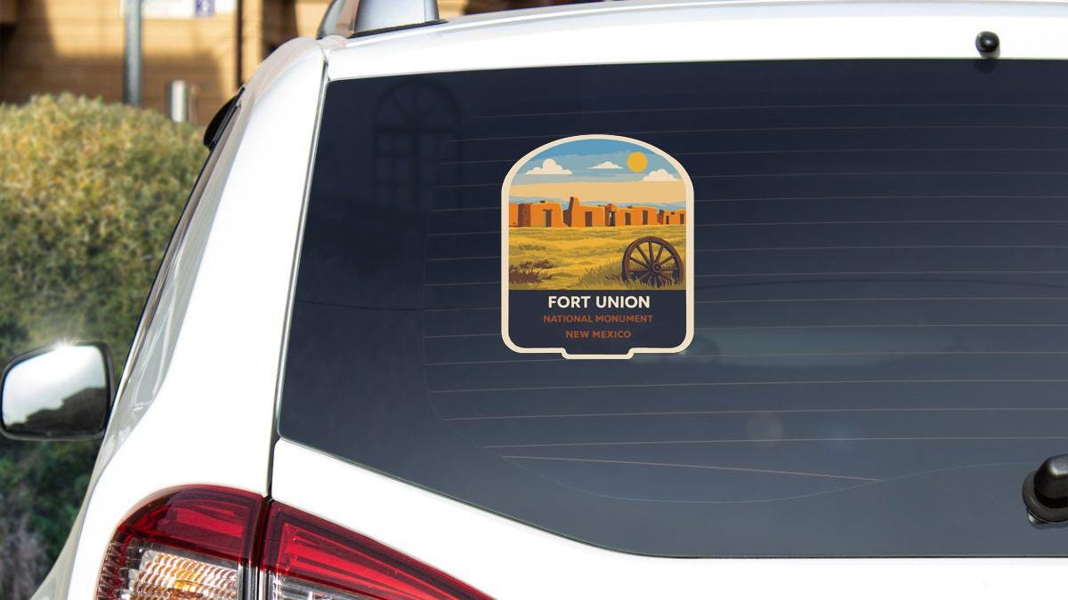a sticker on the rear window of a white car, depicting Fort Union, a national monument in New Mexico.
